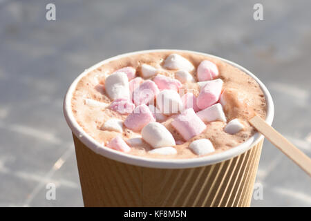 Takeaway cioccolata calda bevanda con marshmellows e un drink in legno agitatore Foto Stock