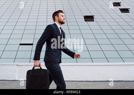 Imprenditore è a piedi con un sacchetto su uno sfondo di business bu Foto Stock