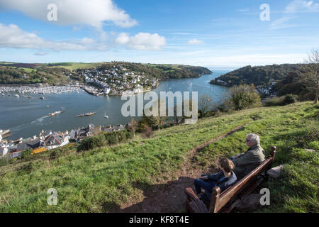 Vista del fiume Dart che si affaccia sul mare e. Kingswear di Bateman's Hill con due persone sedute su un panca godendo della vista spettacolare Foto Stock