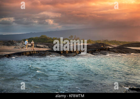 Isole Galapagos, ecuador, un gruppo di persone appendere fuori sulla spiaggia e guardare il tramonto dal Fernandina Island Foto Stock