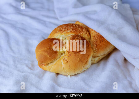 Lo shabbat o sabato cerimonia kiddush composizione con un dolce tradizionale pane fresco di challah pane su un vintage Sfondo legno con spazio di copia Foto Stock