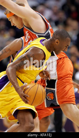 Il Kobe Bryant di Los Angeles Lakers, in primo piano, cerca di passare davanti a Jake Voskuhl di Charlotte Bobcats nella prima metà a Los Angeles venerdì 21 ottobre 2005. Foto di Francis Specker Foto Stock