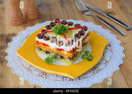 Tradizionale russo stratificato mimosa insalata composta di conserve di pesce coperti con strati di patate bollite, carota, cipolla, formaggio, uova e maionese. Foto Stock