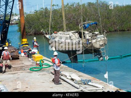 Della guardia costiera statunitense ufficiali ed equipaggi di risposta rimuovere barche danneggiate dal tasto di avvio di Harbour City marina durante gli interventi di soccorso dopo il passaggio dell uragano irma ottobre 16, 2017 in maratona, Florida. (Foto di j.t. blatty via planetpix) Foto Stock