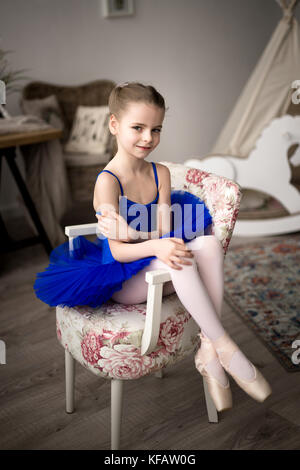 Piccola ragazza sogna di diventare una ballerina. Bambino ragazza in un balletto di blu costume dancing in una stanza. Foto Stock