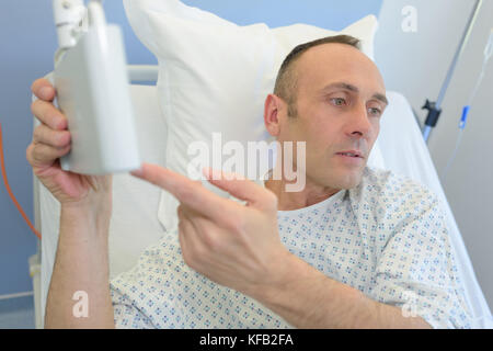 Paziente sul lettino puntando alla macchina Foto Stock
