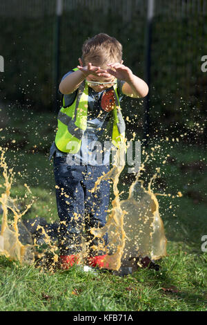 Il mondo Puddle Jumping campionati a Wicksteed Park nel Northamptonshire mercoledì 25 ottobre. I ragazzi sono state facendo un tuffo al mondo Puddle Jumping campionati a Wicksteed Park nel Northamptonshire oggi (MER). I concorrenti si sono battuti per rendere la più grande splash al quinto concorso annuale di Kettering. Gli organizzatori ha creato una speciale serie di campionato standard di pozzanghere e i giudici hanno dato i punteggi basati su cose come altezza del salto, entusiasmo, distanza di splash e stickability (la quantità di fango che si aggrappa a ciascun concorrente). Foto Stock