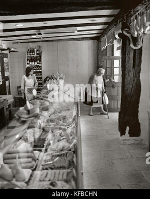 Francia, Borgogna, senior Donna che cammina con la canna da zucchero in charcutier, noyers (b&W) Foto Stock