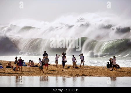 Stati Uniti d'America, Hawaii, Oahu, North Shore, guardare la gente enorme shorebreak e lontane le onde a Waimea Bay Foto Stock