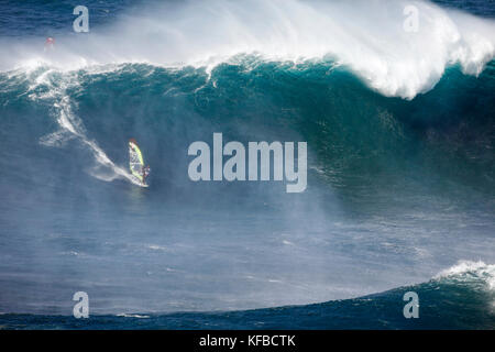 Stati Uniti d'America, Hawaii Maui, un uomo surf sulle onde enormi in corrispondenza di una interruzione chiamati ganasce o peahi Foto Stock