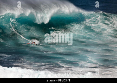 Stati Uniti d'America, Hawaii Maui, un uomo surf sulle onde enormi in corrispondenza di una interruzione chiamati ganasce o peahi Foto Stock