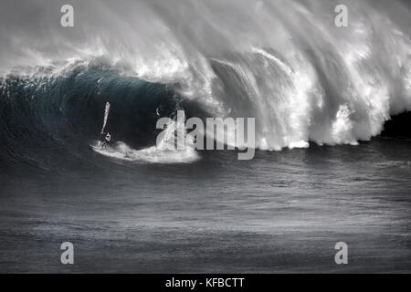 Stati Uniti d'America, Hawaii Maui, un uomo surf sulle onde enormi in corrispondenza di una interruzione chiamati ganasce o peahi (b&W) Foto Stock