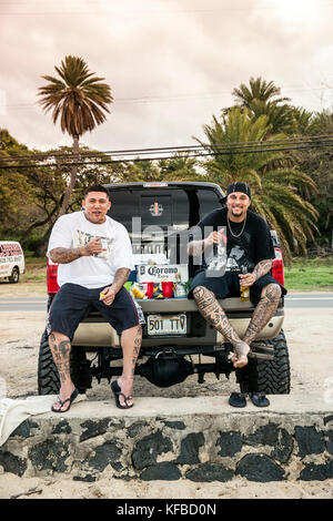 Stati Uniti d'America, Oahu, Hawaii, daytyn ragragola e kenneth meyer jr. sedersi sul retro di un enorme pickup truck sulla North Shore a haliewa beach park Foto Stock