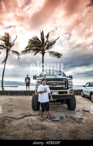 Stati Uniti d'America, Oahu, Hawaii, daytyn ragragola sorge di fronte al suo enorme pickup truck sulla North Shore a haliewa beach park Foto Stock