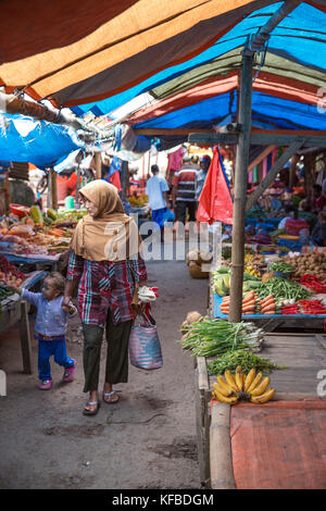 Indonesia, Flores, una donna musulmana e sua figlia sfoglia per produrre a Bajawa mercato a bajawa Foto Stock