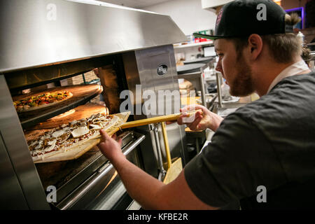 Stati Uniti d'America, oregon, piegare, pacific pizza e birra, uomo di mettere la pizza in forno Foto Stock