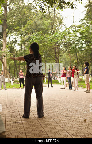 Il Vietnam, Hanoi, donne di allungamento e di esercitare la mattina presto, il lago Hoan Kiem Foto Stock