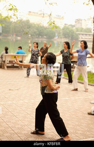 Il Vietnam, Hanoi, donne praticare il tai chi al mattino presto, il lago Hoan Kiem Foto Stock