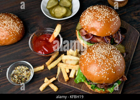 In casa gli hamburger e patatine fritte sul pannello di legno Foto Stock