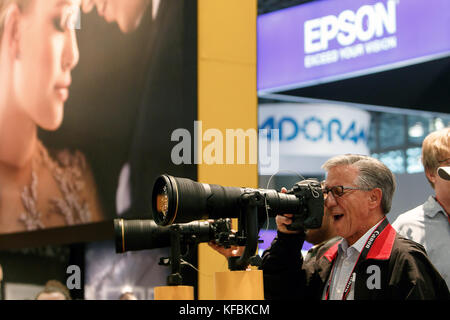 New York, Stati Uniti d'America. 26 ottobre, 2017. Un uomo è alla ricerca attraverso un super teleobiettivo attaccato a una telecamera alla Nikon stand al Photo Expo al Javits Center di Manhattan. Credito: Roman Tiraspolsky/Alamy Live News Foto Stock