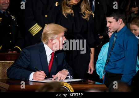 Il presidente degli Stati Uniti Donald J. Trump firma un memorandum presidenziale che dichiara la crisi degli oppioidi un'emergenza sanitaria nazionale mentre parla con due bambini rimasti orfani a causa dell'uso degli oppioidi dei genitori nella stanza orientale della Casa Bianca giovedì 26th ottobre 2017 a Washington, DC Credit: Alex Edelman/CNP /MediaPunch Foto Stock