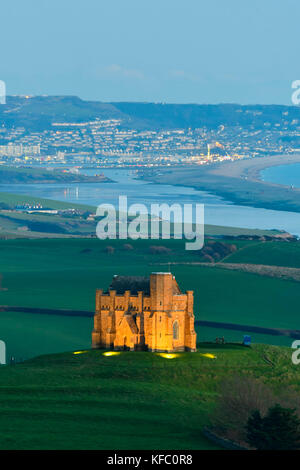 Abbotsbury, Dorset, Regno Unito. Il 27 ottobre 2017. Regno Unito Meteo. Santa Caterina la cappella a Abbotsbury nel Dorset è illuminato al tramonto per l annuale luminarie incantata evento a Abbotsbury giardini subtropicali in una serata di cielo sereno e venti leggeri con una vista lungo la flotta verso l'isola di Portland. Il giorno finale di luminarie presso i giardini è domenica 29 ottobre. Photo credit: Graham Hunt/Alamy Live News Foto Stock