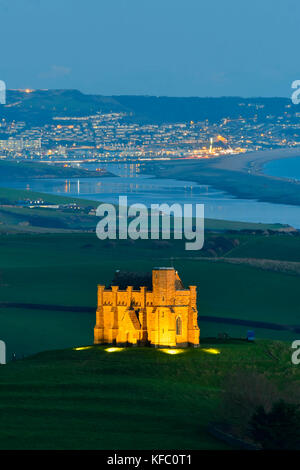 Abbotsbury, Dorset, Regno Unito. Il 27 ottobre 2017. Regno Unito Meteo. Santa Caterina la cappella a Abbotsbury nel Dorset è illuminato al tramonto per l annuale luminarie incantata evento a Abbotsbury giardini subtropicali in una serata di cielo sereno e venti leggeri con una vista lungo la flotta verso l'isola di Portland. Il giorno finale di luminarie presso i giardini è domenica 29 ottobre. Photo credit: Graham Hunt/Alamy Live News Foto Stock