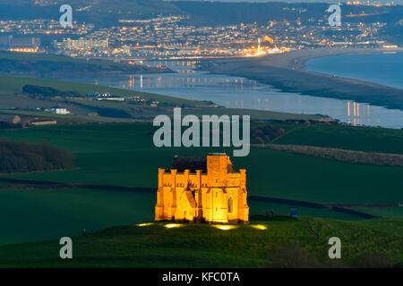 Abbotsbury, Dorset, Regno Unito. Il 27 ottobre 2017. Regno Unito Meteo. Santa Caterina la cappella a Abbotsbury nel Dorset è illuminato al tramonto per l annuale luminarie incantata evento a Abbotsbury giardini subtropicali in una serata di cielo sereno e venti leggeri con una vista lungo la flotta verso l'isola di Portland. Il giorno finale di luminarie presso i giardini è domenica 29 ottobre. Photo credit: Graham Hunt/Alamy Live News Foto Stock