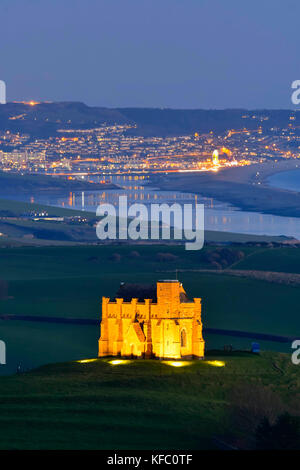 Abbotsbury, Dorset, Regno Unito. Il 27 ottobre 2017. Regno Unito Meteo. Santa Caterina la cappella a Abbotsbury nel Dorset è illuminato al tramonto per l annuale luminarie incantata evento a Abbotsbury giardini subtropicali in una serata di cielo sereno e venti leggeri con una vista lungo la flotta verso l'isola di Portland. Il giorno finale di luminarie presso i giardini è domenica 29 ottobre. Photo credit: Graham Hunt/Alamy Live News Foto Stock