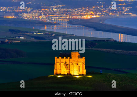 Abbotsbury, Dorset, Regno Unito. Il 27 ottobre 2017. Regno Unito Meteo. Santa Caterina la cappella a Abbotsbury nel Dorset è illuminato al tramonto per l annuale luminarie incantata evento a Abbotsbury giardini subtropicali in una serata di cielo sereno e venti leggeri con una vista lungo la flotta verso l'isola di Portland. Il giorno finale di luminarie presso i giardini è domenica 29 ottobre. Photo credit: Graham Hunt/Alamy Live News Foto Stock