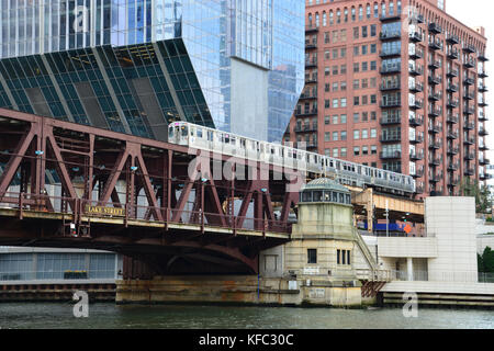 Una linea rosa L treno attraversa il fiume Chicago a Lake Street di fronte al grattacielo a sbalzo a 150 N Riverside a Chicago Foto Stock