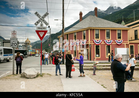 Stati Uniti d'America Alaska, Sitka, individui camminando per le strade del centro cittadino di sitka attendere il treno che viaggia sul white pass & yukon route railroad per passare Foto Stock