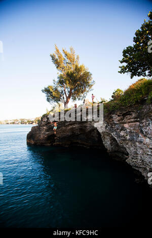 BERMUDA. Parrocchia di Hamilton. Cliff jumping, nuoto fuori da un punto nella Admiralty House Park di Hamilton. Foto Stock