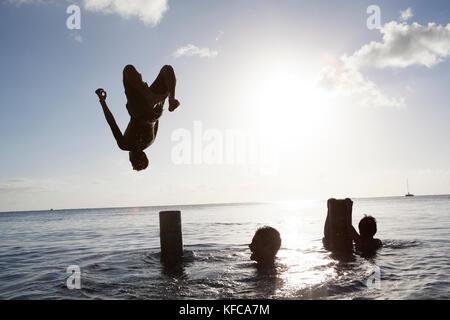 Polinesia francese, Isola Raiatea. Bambini locali nuoto e giocare lungo la costa. Foto Stock