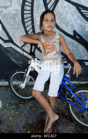 Polinesia Francese, Moorea. Bambini locali lo skateboard e mountain bike. Foto Stock