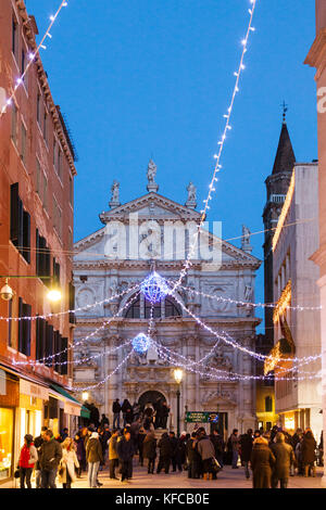 L'Italia, Venezia. Le decorazioni di Natale pende su Campo San Moise lungo Calle Larga XXII Marzo. La Chiesa di San Moise è al centro e la parte anteriore 0 Foto Stock