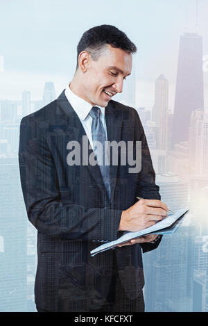 Piacevole happy businessman scrivendo un piano Foto Stock