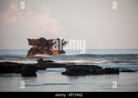 Bali seascape un carattere meditativo scena della pila di rock e onde. un close-up immagine utilizzando una lunga esposizione tecnica e la profondità di campo ridotta al crepuscolo Foto Stock