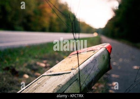 Una strada con un giallo rotto e segno di un'auto. Foto Stock