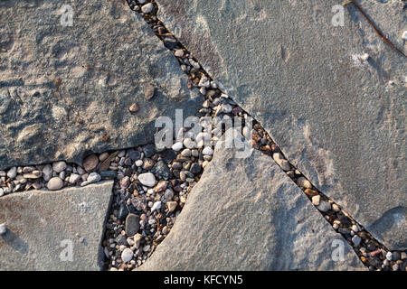 Un frammento di piastrelle in pietra. una strada nel parco della città. frammenti di piastrelle in pietra e piccole pietre tra. Foto Stock