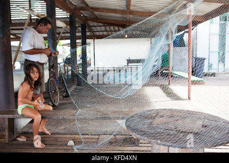 Polinesia francese, Tahiti. Un pescatore locale che fissa la sua Tutina in rete nel villaggio di Vairao situato lungo la costa meridionale dell'isola di Tahiti. Foto Stock