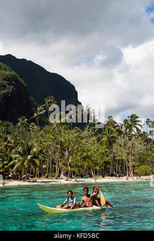 Polinesia Francese, Moorea. Giovani ragazzi in canoa a baia Opunohu. Foto Stock