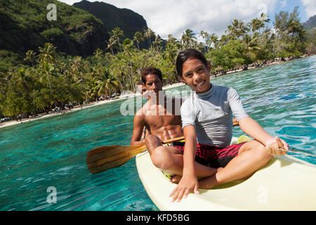 Polinesia Francese, Moorea. Giovani ragazzi in canoa a baia Opunohu. Foto Stock