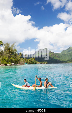 Polinesia Francese, Moorea. Giovani ragazzi in canoa a baia Opunohu. Foto Stock