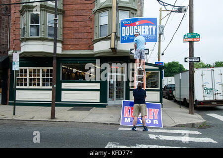 La manodopera europea membri mount indicazioni a sostegno di un candidato, al di fuori di un popolare South Philadelphia, PA diner e punto di incontro per i politici locali, su E Foto Stock