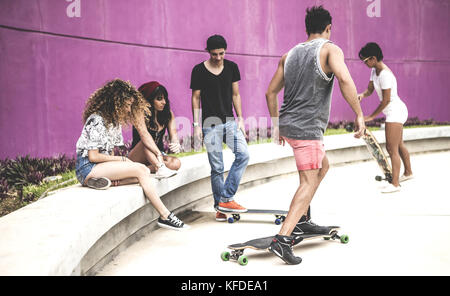 Un gruppo di giovani skateboarders in uno skate park. Foto Stock