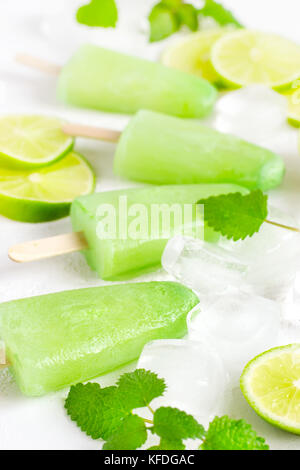 Un sano menta lime popsicles con un fresco e fettine di lime e i cubetti di ghiaccio. Messa a fuoco selettiva Foto Stock