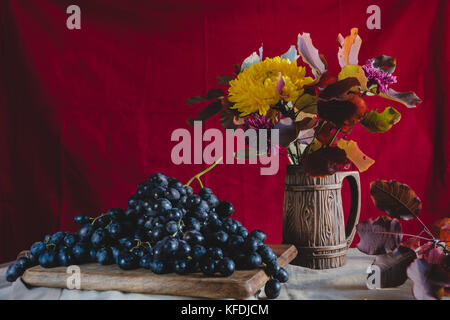 Autunno still life uve, autunno fiori e foglie Foto Stock