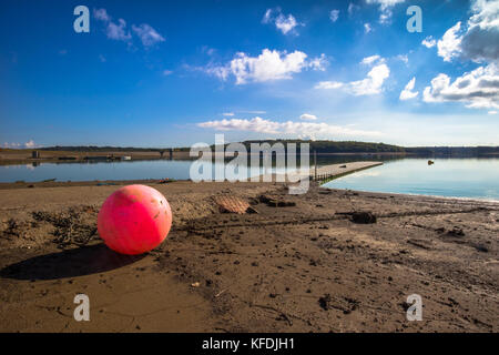 Bewl serbatoio acqua kent siccità di basso livello acqua litorale sfuggente presso il molo al kent su un soleggiato blue sky giorno con soffici nuvole e boa rosa Foto Stock