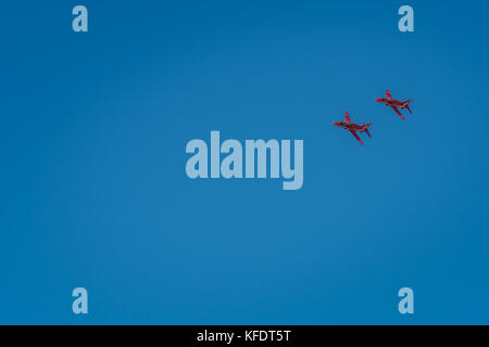 Due aerei a freccia rossa volano attraverso il cielo blu. Foto Stock